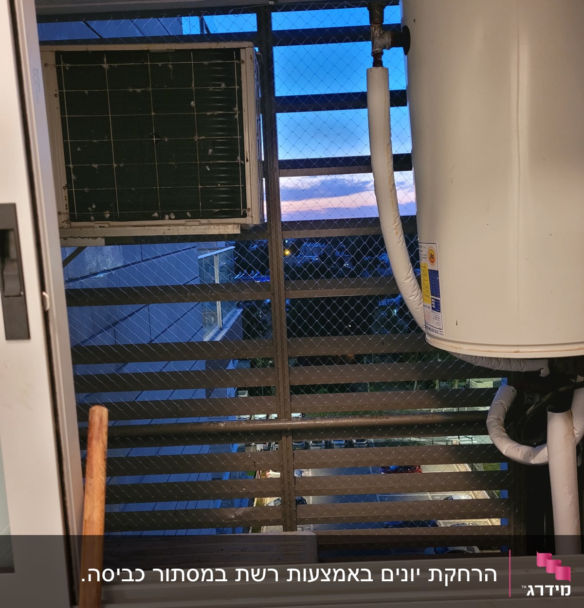 יחידת מזגן ורשת מתכת על חלון